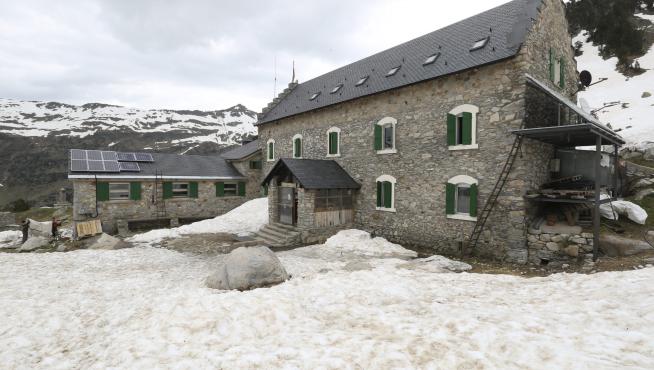 Un helicóptero transportó esta semana los suministros necesarios para los próximos meses. En el centro, Antonio Lafón con su mujer, María Romero, y su hijo David, en la cocina. En el refugio todavía se acumula mucha nieve.