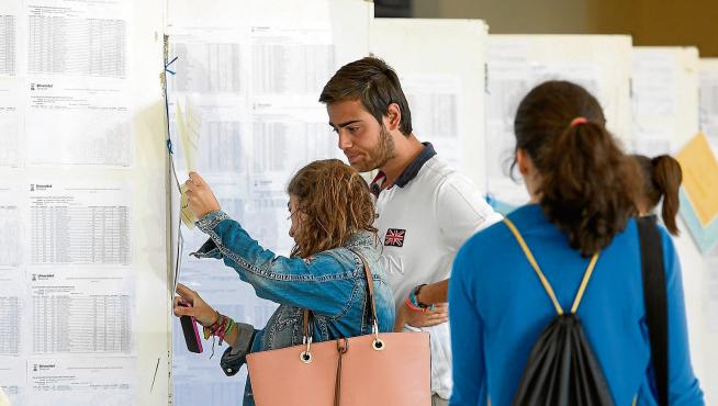 Dos personas consultan las listas de espera de los grados de la Universidad de Zaragoza, esta semana.
