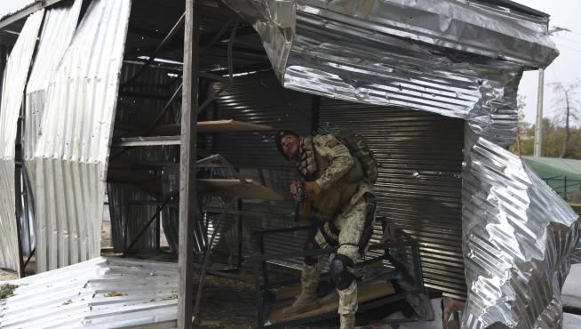 Un soldado inspecciona el lugar donde ha explotado una de las bombas en Jalalabad, Afganistán.