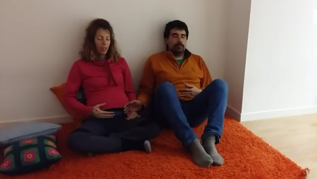 Una pareja que espera un bebé escucha música.