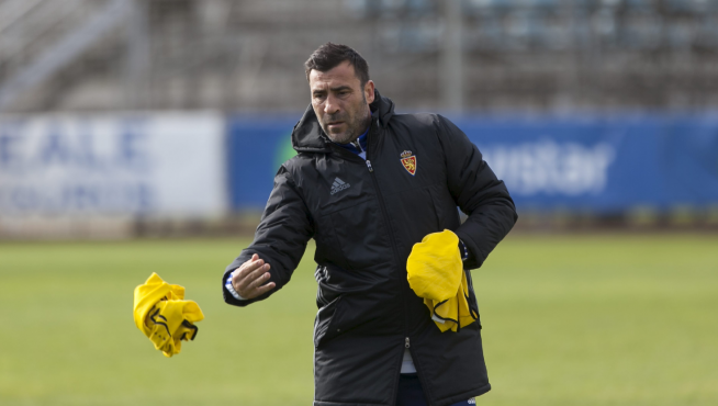 Raúl Agné, repartiendo petos amarillos, en el entrenamiento del Real Zaragoza en la Ciudad Deportiva.