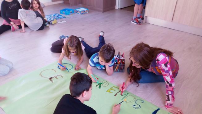 Los niños pintan una pancarta, en el centro de tiempo libre El Globo de Parque Goya
