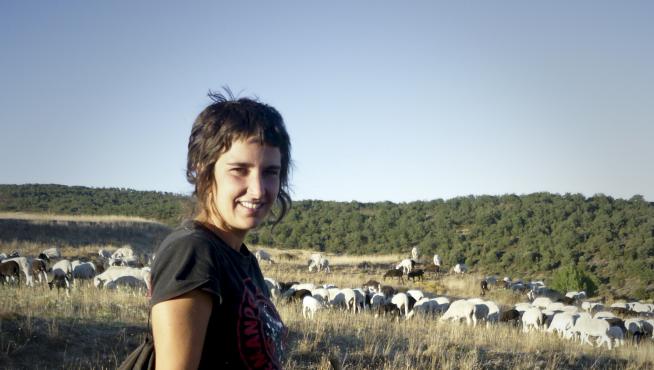 Lorena Genzor , con su can de chira de tres meses Oza y su rebaño al fondo, pastoreando en el término de Pobar (Soria).
