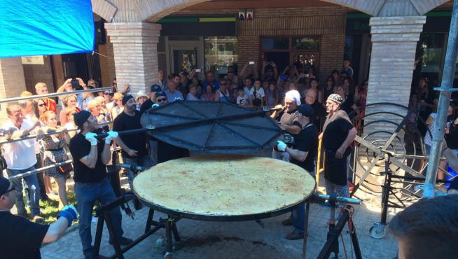 Vecinos de Osera de Ebro y Pina dándole la vuelta a la tortilla de patata más grande de Aragón