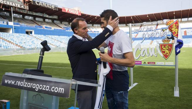 El presidente del Real Zaragoza, Christian Lapetra, entrega una camiseta conmemorativa a Cani, ayer en La Romareda.