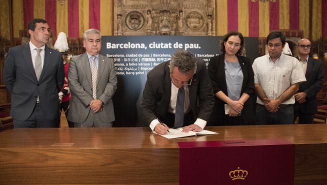 El consejero de Interior, Joaquim Forn, firma en el libro de condolencias del Ayuntamiento de Barcelona.