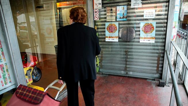 Una mujer ante las puertas cerradas en el mercado de San Antoni