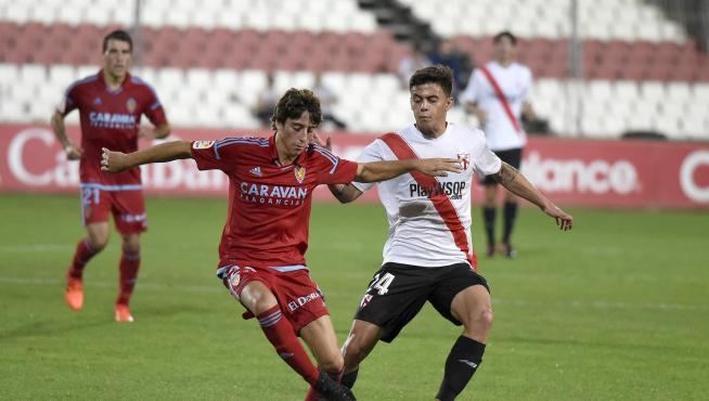 Julián Delmás avanza con la pelota ante la oposición de Felipe Carballo.