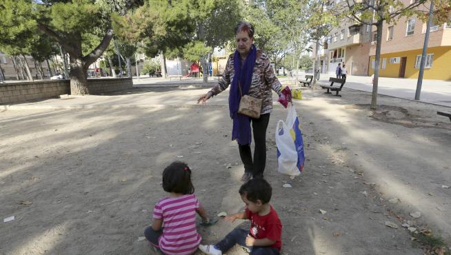 Una señora atiende a sus nietos en una de las zonas del parque de San Martín de Huesca.