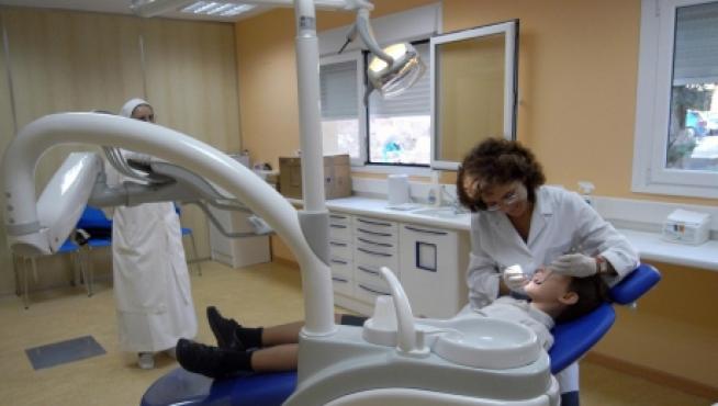 Un dentista atendiendo a un niño, en una foto de archivo.