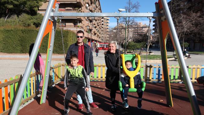 Lizer, en el nuevo columpio adaptado del parque de la Aljafería, con sus padres y su hermano.