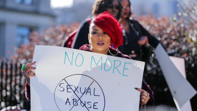 Una mujer sostiene un cartel que reza 'No más abusos sexuales' durante una protesta