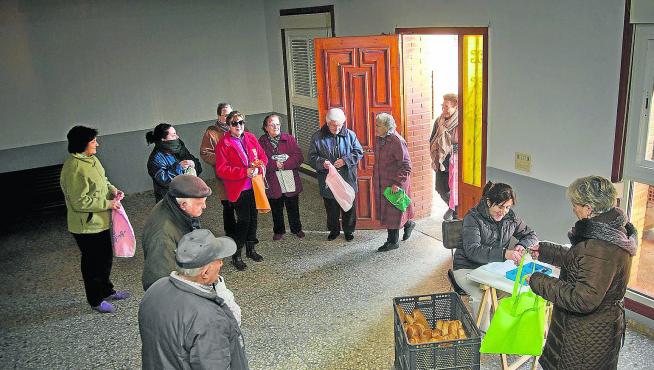 Charo Tirado hace el reparto de pan a los vecinos de Alarba en los bajos del Ayuntamiento.