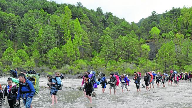 Los participantes en los campamentos tienen que cruzar el río para llegar al pueblo de Griébal.