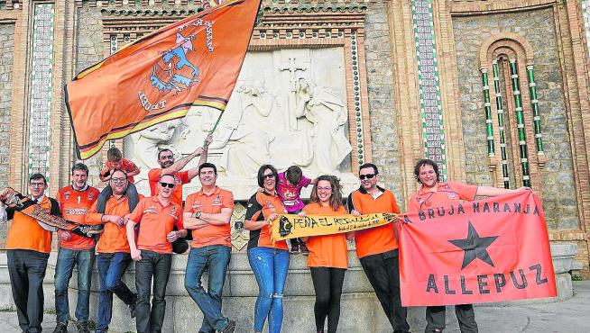 Representantes de las peñas naranjas posan en La Escalinata ilusionados con ganar el triplete en la cancha del eterno rival, el Unicaja.