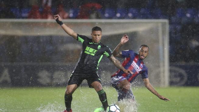 Carlos Akapo lucha con el ex azulgrana Machís durante el Huesca-Granada que supuso el regreso del internacional ecuatoguineano.