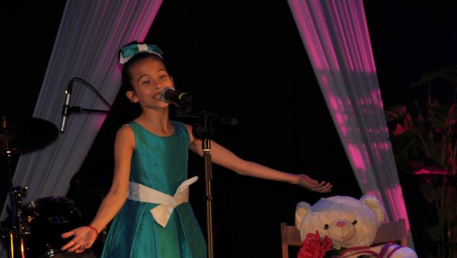 Melani, en el escenario, durante su actuación en Alagón, con su inseparable 'Abracitos'.