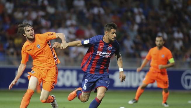 Eugeni, a la izquierda, le disputa el balón a Luso en el Huesca-Lorca de la pasada temporada.