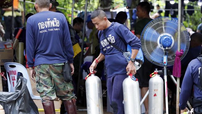 Personal de la marina tailandesa cargando tanques de oxígeno durante las operaciones de rescate.