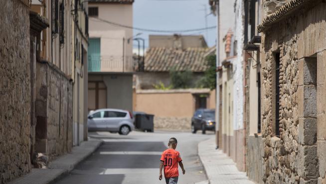 Un niño con la camiseta de Messi anda por las calles del pueblo