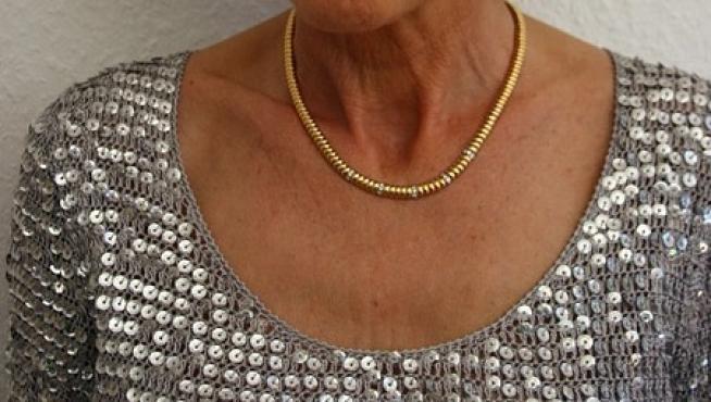 Imagen de una señora con una cadena de oro.