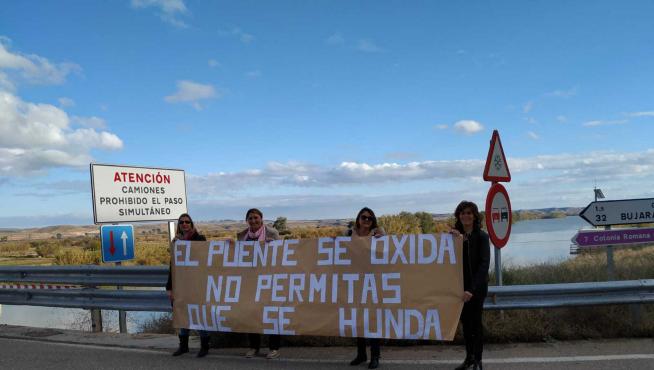 Reyes, Mari Carmen, María José y Tere, madres de alumnos, con una pancarta en el puente.