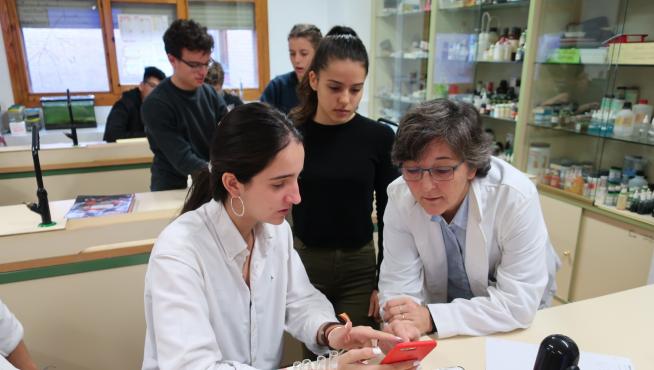 Olga Villagrasa, con sus alumnos de 1º de Bachillerato en el laboratorio, en una práctica con móviles.