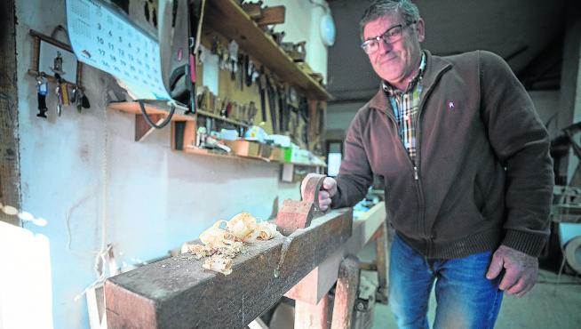 Eduardo Condón saca virutas de madera en el taller de su casa.