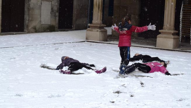 Niños jugando a hacer un ángel en la nieve en la localidad de Graus.