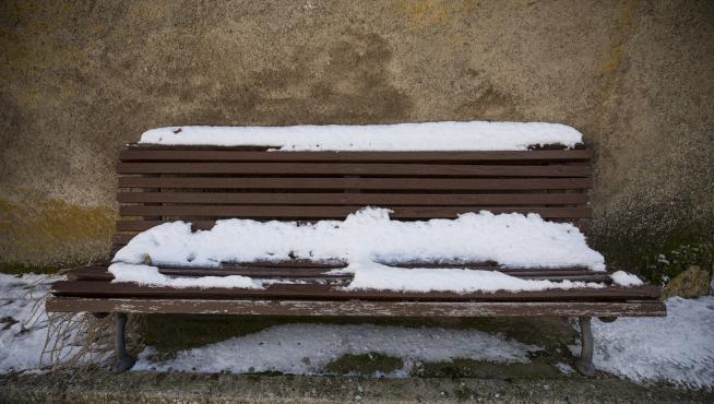Hermosa estampa de un banco de madera nevado, en una de las pocas jornadas de este invierno con manto blanco en Lanzuela.