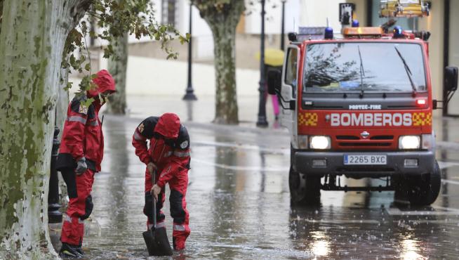 Bomberos de Huesca desatascando un desagüe durante una tromba