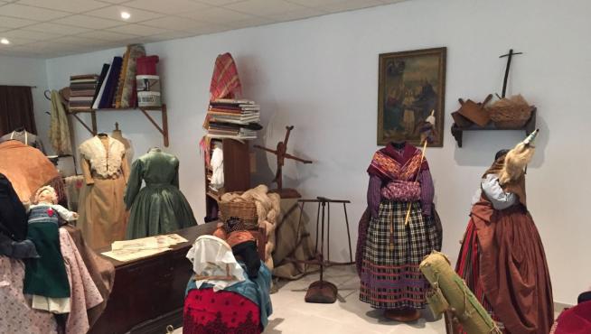 Espacio Indumentaria de Valdealgorfa. En primer plano, una escena de hilanderas, con los demoré y las devanaderas para hacer madejas y ovillos.