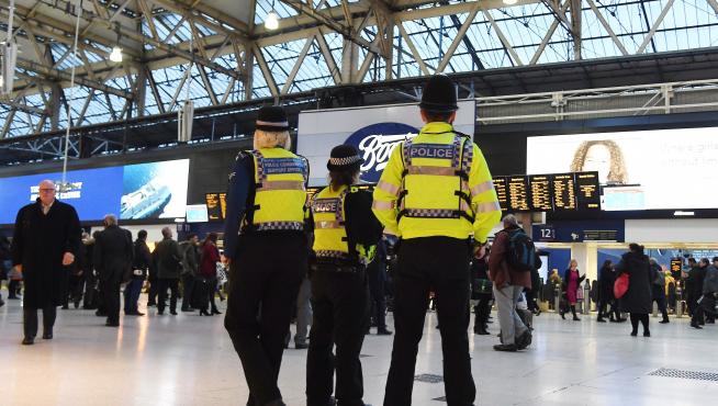 Agentes de policía montan guardia en la estación de tren de Waterloo, este martes en Londres (Reino Unido). La policía británica investiga tres paquetes con pequeños dispositivos explosivos caseros que fueron recibidos hoy en edificios de los aeropuertos