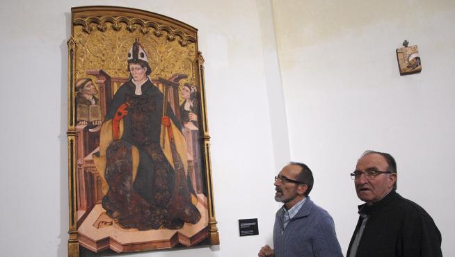 El alcalde de Tamarite y el anterior alcalde de Algayón, con la réplica del retablo.