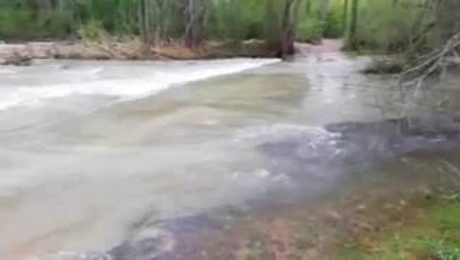La crecida del río Mijares a su paso por la localidad turolense de Olba ha dejado a los vecinos del barrio de los Tarrasones aislados, sin poder salir de sus casas.