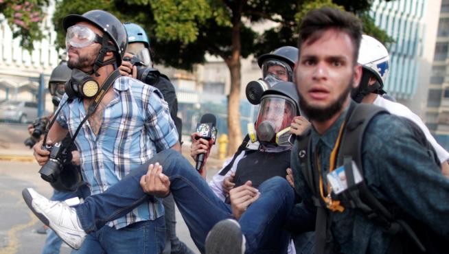 Un periodista herido en las protestas es trasladado por varias personas en Caracas