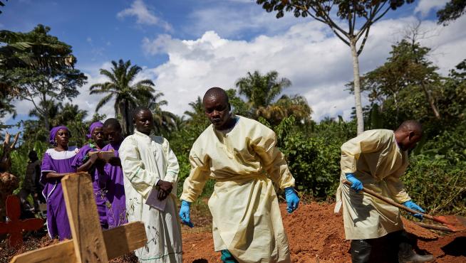 Varios trabajadores sanitarios entierran el cadáver de un hombre que se infectó con ébola tras compartir habitación de hospital con un paciente enfermo en Beni (República Democrática del Congo).