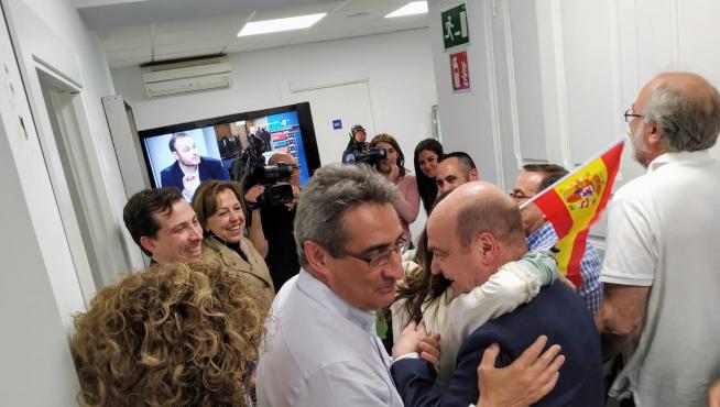 El líder de Vox en Aragón, Santiago Morón, se funde en un abrazo con una militante, al paso del nuevo concejal del partido en Zaragoza, Julio Calvo.
