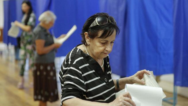 Una mujer deposita su voto en las elecciones al parlamento de Ucrania.