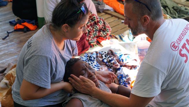 Dos sanitarios atienden a uno de los inmigrantes del Open Arms