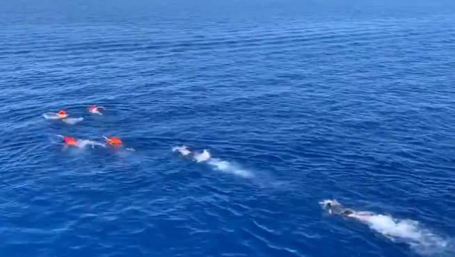 Migrantes del Open Arms se lanzan al agua para alcanzar Lampedusa.