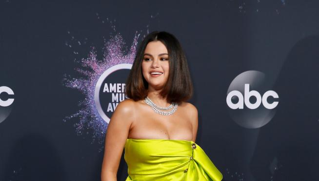 Selena Gomez en la alfombra roja de los American Music Awards con su llamativo vestido amarillo