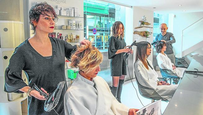 Varias trabajadoras atienden a sus clientas en una peluquería.