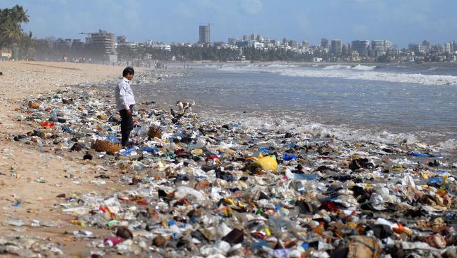 Un hombre observa una montaña de plásticos a orillas del mar Arábigo en Bombay (La India).