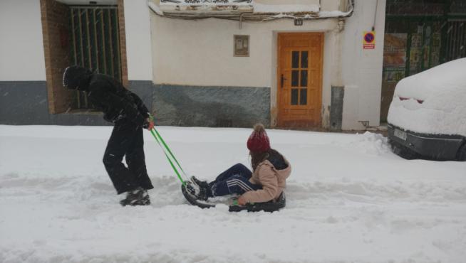Dos niñas jugando con un trineo en Paniza