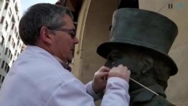 Dos técnicos de la unidad de restauración del Ayuntamiento de Zaragoza realizan labores de limpieza en el busto de Felipe Sanclemente situado en el paseo de la Independencia