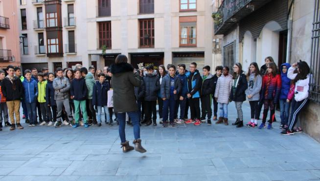 Los niños reciben las explicaciones de la técnico de FTM en la plaza de España, junto al Ayuntamiento