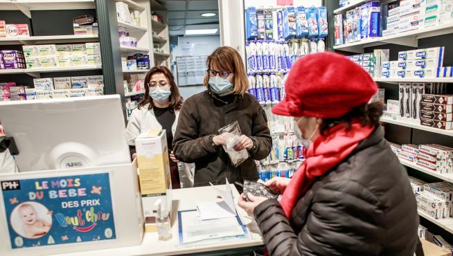 Varias personas con mascarillas este martes en una farmacia de París.
