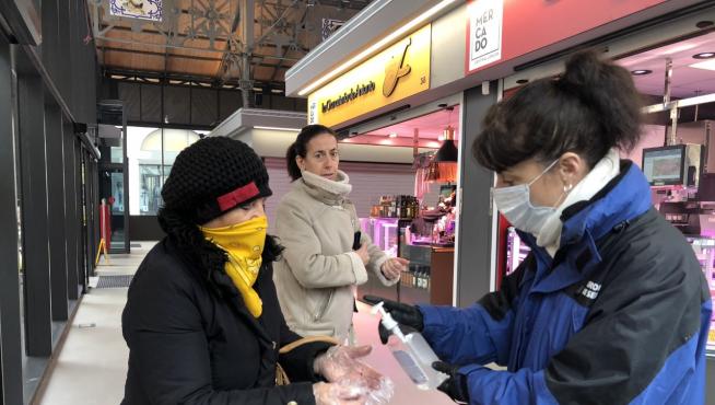 Una clienta del Mercado Central de Lanuza se lava las manos con jabón desinfectante antes de comprar.
