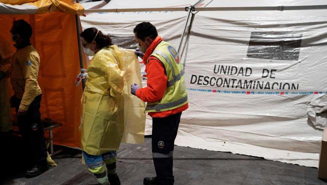 GRAF246. MADRID, 22/03/2020.- Personal sanitario accede por una zona protegida mientras comienzan a llegar los pacientes con coronavirus anoche a uno de los pabellones del recinto ferial Ifema habilitados para albergar 1.396 camas, en Madrid. EFE/ Comunidad De Madrid Llegada de pacientes al Ifema